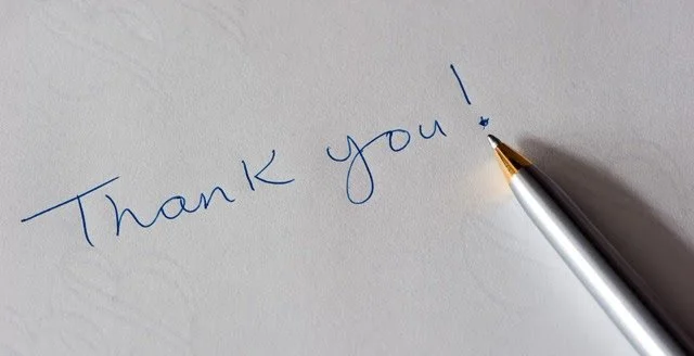 The words thank you written on a sheet of paper with an exclamation mark and a pen at end to illustrate testimonials page.