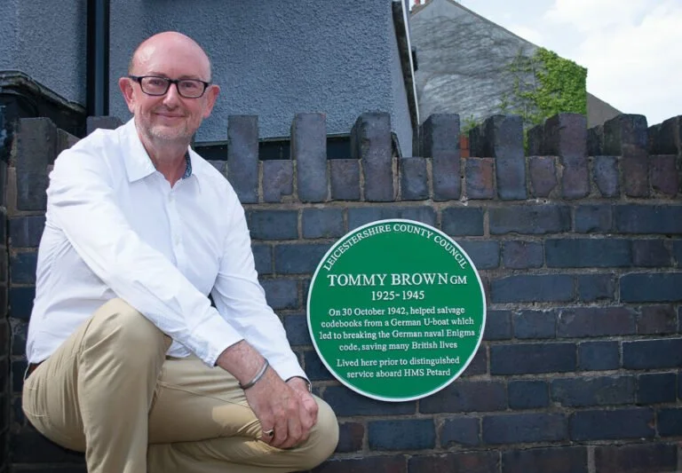 Phil Shanahan, who led campaign to honour three Enigma heroes, is next to plaque at the Earl Shilton house where Tommy Brown lived.